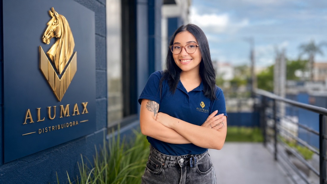 Consultora comercial Alumax ao lado do logo na fachada da sede